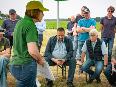 Annette Hoffmann (l., Pflanzenbau) beim Feldtag zum Thema Landwirtschaft und Wasserschutz; unter den Zuh&ouml;rern sind  Landvolk-Pr&auml;sident Dr. Holger Hennies (M.) und rechts neben ihm CDU-Agrarexperte Dr. Frank Schm&auml;deke.