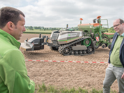 Niedersachsens Umweltminister Christian Meyer (r.) l&auml;sst sich von LWK-Technikexperte Dr. Harm Dr&uuml;cker den autonomen Feldroboter AgBot erkl&auml;ren.