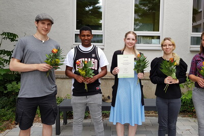 Hauswirtschafter*innen Göttingen - © Astrid Grupe Fünf Personen stehen vor einem Gebäude, halten Blumensträuße und eine Person hält ein Zertifikat.