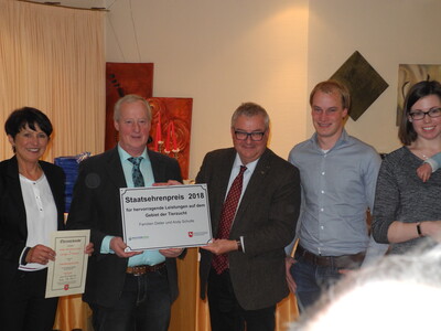 (von links: Hildegard und Dieter Schulte erhalten von Staatssekretär Beckedorf den Staatsehrenpreis gemeinsam mit Andy und Anna Schulte)