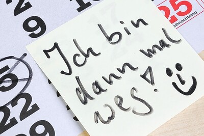 Kalender zeigt Dezember 2020, der 15. ist eingekreist. Ein Zettel mit "Ich bin dann mal weg!" und einem Smiley liegt darauf.