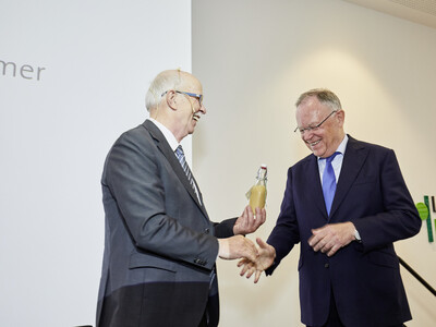 Kammerpr&auml;sident Gerhard Schwetje (l.) &uuml;berreicht Ministerpr&auml;sident Stephan Weil w&auml;hrend des Festakts zum 125-j&auml;hrigen Bestehen der Landwirtschaftskammer Niedersachsen am 21.05.2024 in Hannover-Ahlem eine Flasche selbst hergestellten Eierlik&ouml;r.