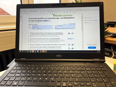 Ein Laptop auf einem Schreibtisch zeigt ein Dokument mit dem Titel "Niedersachsen Entscheidungshilfe 2023".