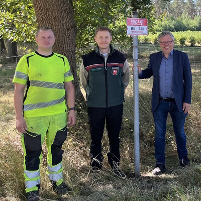 Aufstellung des ersten neuen Notfall-Schildes mit (v.r.) Björn Gehrs, Bürgermeister der Samtgemeinde Schwarmstedt, Christoph Grünhage (LWK) und einem Mitarbeiter des Bauhofs der Samtgemeinde.