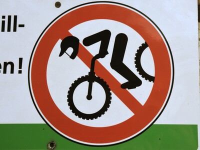 Schilder im Wald weisen darauf hin, dass Downhill-Fahrten verboten sind.