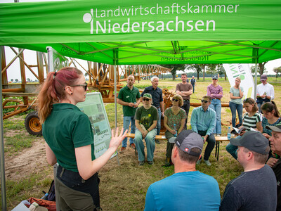Marisa Sonntag (vorn, Fachbereich Wassermanagement, Wasser- und Bodenschutz) und Dr. Kilian Loesch (Hintergrund, l., Landtechnik, Energie, Bauen, Immissionsschutz) beim Feldtag zum Thema Landwirtschaft und Wasserschutz am 17.06.2026 in Schw&uuml;blingsen.