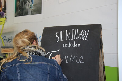 Bei ihrem Kreativworkshop zeigt Christine Gehle den Teilnehmer*innen Beispiele für originelle Tafelbeschriftungen.
